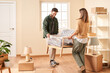 © Martí Sans/Stocksy - Young couple carrying armchair together