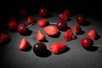 Summer fruit, several cherries and strawberries on a table