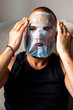 © Eloisa Ramos/Stocksy - portrait of modern man with a facial mask