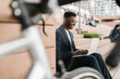 © Mihajlo Ckovric/Stocksy - Young businessman using a laptop outdoors