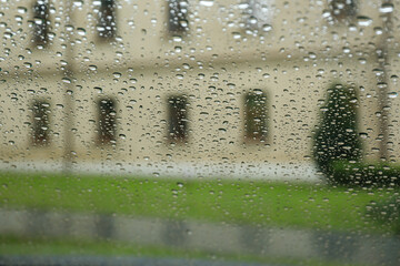 Wall Mural - Blurred view of city street through wet car window. Rainy weather