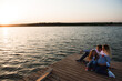 © nagaets - a pregnant mother, her husbant and daughter relaxing on the bridge by the river