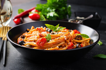 Wall Mural - Spaghetti alla puttanesca - italian pasta dish with tomatoes, black olives, capers, anchovies and basil. Top view, flat lay