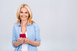 © denis_vermenko - Happy mature senior woman holding smartphone using mobile online apps, smiling old middle aged lady texting sms message chatting on phone looking at cellphone isolated on white grey background
