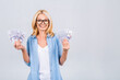 © denis_vermenko - Happy winner! Image of a mature senior happy old woman standing isolated over a white wall background, looking at the camera holding money.