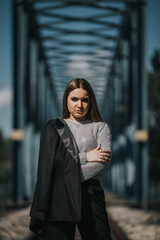 Sticker - Pretty blonde Caucasian lady with a blazer on her shoulder posing on the railroad