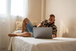 © Eloisa Ramos/Stocksy - Modern man watching a film in his laptop at bedroom