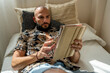 © Eloisa Ramos/Stocksy - modern man relaxing with his tablet at home