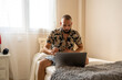 © Eloisa Ramos/Stocksy - Modern man using his laptop at home