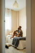 © Eloisa Ramos/Stocksy - Hipster man looking the window on the bed