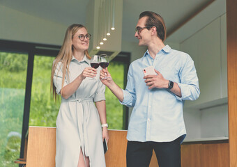 Happy couple holding glasses with red wine and celebrating