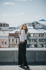 Wall Mural - Pretty Caucasian lady wearing heels and posing on a bridge