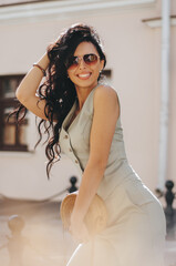 Wall Mural - young woman aged 27-30 years with dark long hair in summer in sunglasses.