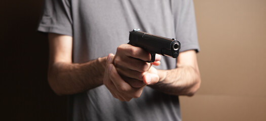 a man holding a black pistol in his hand threatening