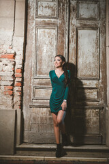 Canvas Print - Young sexy Caucasian girl posing in front of an old weathered wooden door