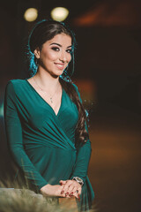 Sticker - Vertical shot of a young Caucasian female posing in an elegant green dress in the street at night