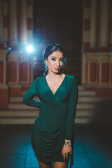 Canvas Print - Pretty Caucasian lady with a green evening dress posing in front of a restaurant building