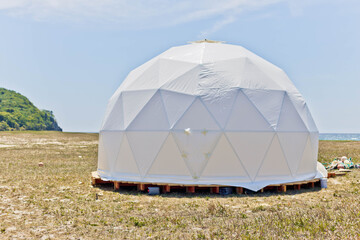 white tent geodesic dome camp in nature. glamping.