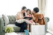 © Kris Tan - Asian Parents and a kid child look at a laptop at home. Family concept.
