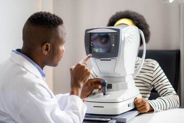 optician doing optometry eye exam of black african american teen girl in modern clinic. doctor and p