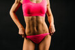 © Ivan Zelenin - Beautiful young sporty muscular woman, isolated against dark background