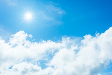 Wall Mural - sun with sunlight in white clouds on blue sky.
