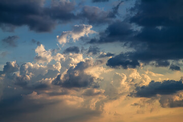 cloudy sky at sunset. cumulus clouds painted in golden and blue colors. dramatic heavenly landscape.