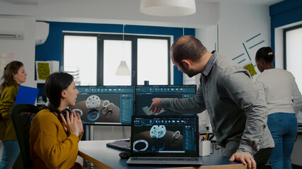 Wall Mural - Teamwork sharing ideas about industrial project analysing 3D gears looking at computer with CAD software compering with model from laptop. Industrial engineer and manager working in creative office