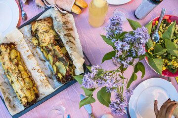 Stockholm, Sweden An outdoor dinner consisting of potato roll baked in the oven and drinks.