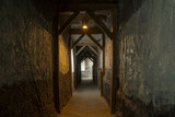 Fototapeta Desenie - Long lighten tunnel through gypsum mine with wooden beams in north of Thailand.