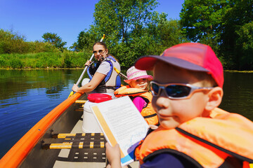 a family on a canoe excursion in summer - active vacation