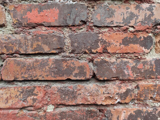 Poster - Closeup shot of an old red brick wall with fainted paint