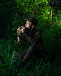 © ISliM - Peter Pan plays a flat sitting in the grass against the backdrop of the forest. Cosplay on Peter Foam. Robin Hood