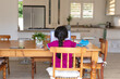© Wavebreak Media - Hispanic girl sitting at kitchen table doing school work using laptop