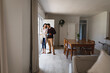 © Wavebreak Media - Hispanic couple standing in kitchen drinking coffee and looking out of window