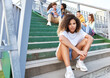 © gpointstudio - Portrait of young African woman sitting on the stairs