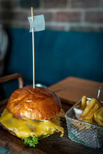 Tasty Big Burger On Wooden Table. Juicy Burger And Fries