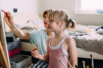 Wall Mural - beautiful mother artist and her child paint picture at home with acrylic paints.