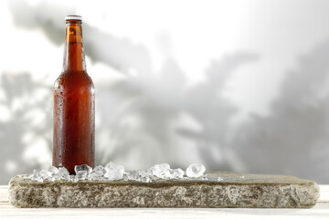 Wall Mural - Beer on the table on a summer day with leaf shadows on the wall and ice cubes 