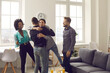 © Studio Romantic - It's good to see you after such a long time. Group of diverse young people happy to meet their friend at a reunion party at home. Bunch of excited men and women hugging friend who they missed so much