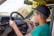 © vitec40 - a boy in a cap sits at the wheel of a car