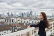 © Annika List/Westend61 - Thoughtful businesswoman looking at cityscape view on building terrace