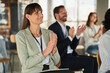 © Annika List/Westend61 - Businesswoman clapping hands with colleagues in conference centre