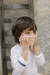 © Alberto Bogo/Westend61 - Cute boy covering face with dough at back yard