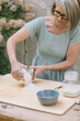 © Alberto Bogo/Westend61 - Mature woman putting flour on plank at back yard
