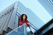 © Antonio Ovejero Diaz/Westend61 - Caucasian young man leaning on railing while modern office building in background