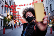 Woman Wearing Protective Face Mask Taking Selfie During Vacations At Chinatown During COVID-19
