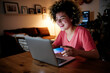 © Angel Santana Garcia/Westend61 - Cheerful young woman with laptop doing online shopping at home