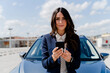 © Francesco Morandini/Westend61 - Female professional with smart phone near car