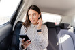 © Francesco Morandini/Westend61 - Female professional talking through in-ear headphones while holding smart phone in car